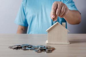 person putting coin on the piggybank on table, donation,  charity, fundraising, superannuation, investment,saving,family finance plan concept, Money Saving Ideas for Buying a Home. photo