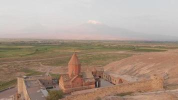 Aerial zoom out view historical landmark in Armenia - Khor Virap monastery with Ararat mountain peak background at sunrise video
