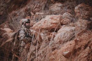 soldados de fuerzas especiales en guerras en el desierto, gente de tailandia, soldado del ejército usan una computadora portátil para ver el mapa con satélite, usan radio para comunicarse durante la operación militar foto