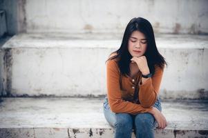 cerrar la angustia de una mujer asiática triste por un amor no correspondido, concepto de niña joven de corazón roto, estilo vintage, tono oscuro foto