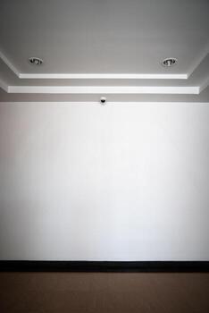 CCTV camera is installed in front of the empty backdrop wall on the ceiling  for monitoring and running safety system control in that area. photo