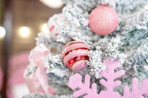 el árbol de navidad con copos de nieve está decorado con bolas, regalos y regalos en tema rosa para el evento de navidad y año nuevo foto