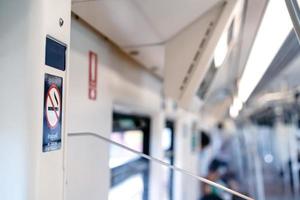 The No Smoking Sticker on the BTS train wall with blur background. Texts on the sticker means No Smoking photo