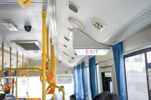 Exit sign light box is hung on the ceiling inside the bus, Thailand. photo