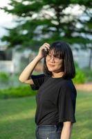 Portrait of the Asian glassese Thai woman is standing in the garden in the morning. photo