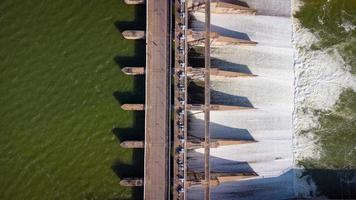 An aerial view over the Pasak Jolasid dam, Lopburi Province, Thailand. Tracking the movement of the floodgates that are releasing water into rural canals in enormous amounts of water. photo