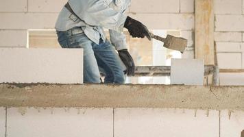 Construction workers are making white lightweight concrete blocks that are better than cement bricks, popular in the construction of homes and public buildings. photo