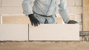 Construction workers are making white lightweight concrete blocks that are better than cement bricks, popular in the construction of homes and public buildings. photo