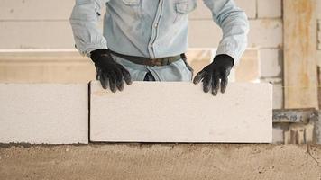 Construction workers are making white lightweight concrete blocks that are better than cement bricks, popular in the construction of homes and public buildings. photo