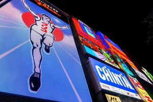 Osaka, Japan,2019 - Look up view colorful and eye-catching advertising lights billboards at Dotonburi area.  Dotonbori is a one popular destination of Osaka when tourists traveling Osaka. photo