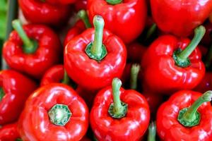 Closeup and crop heap of red bell pepper fit on screen background and wallpaper. photo