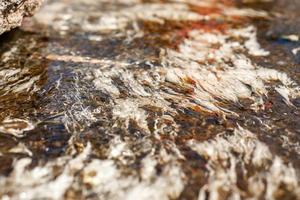 Background and textured of albumen in clear natural hot spring watercourse caused by the cracking of eggs that tourists bring to boil. It's look to white hair and art of nature. photo