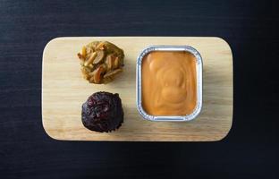 Chocolate muffin, banana cupcake and milk tea fudge cake on wooden tray photo