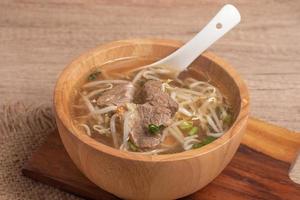 clear stewed pork soup in a wooden bowl photo