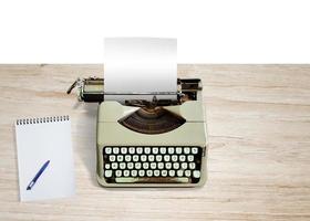 Old typewriter with notebook on wooden table. Top view. photo