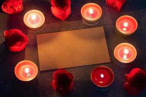 Red roses and burning candles, close up, romantic greeting card. concept of Valentine's Day. photo