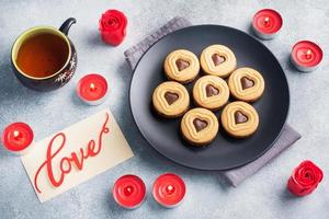 Homemade cookies in the shape of hearts on the plate, gray background. Concept Valentine's Day. copy space. photo