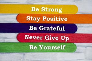 Motivational text on colorful sticks - Be strong, stay positive, be grateful, never give up and be yourself. Motivation and inspirational quote. photo