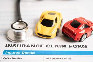 Stethoscope on Insurance claim accident car form, Car loan, insurance and leasing time concepts. photo