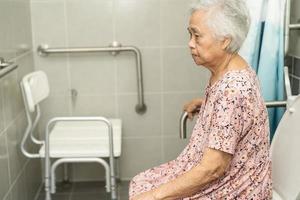 Asian senior or elderly old lady woman patient use toilet bathroom handle security in nursing hospital ward, healthy strong medical concept. photo