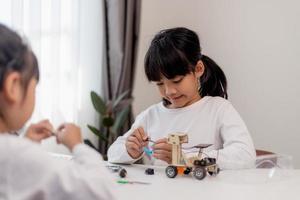 Asia students learn at home in coding robot cars and electronic board cables in STEM, STEAM, mathematics engineering science technology computer code in robotics for kids concept. photo