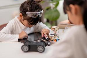 Asia students learn at home in coding robot cars and electronic board cables in STEM, STEAM, mathematics engineering science technology computer code in robotics for kids concept. photo