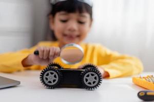 Asia students learn at home in coding robot cars and electronic board cables in STEM, STEAM, mathematics engineering science technology computer code in robotics for kids concept. photo