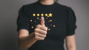 Customer satisfaction concept. Hand with thumb up Positive emotion smiley face icon and five star with copy space. photo