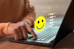 Man hand using computer laptop with popup five star icon for feedback review satisfaction service, testimonial. Customer service experience and business satisfaction survey. photo