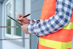 Inspector or engineer is checking and inspecting the building or house by using checklist. Engineers and architects work on building the house before handing it over to the landlord. photo