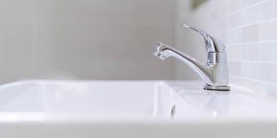 The bathroom faucet is turned off to save water energy and protect the environment. water saving concept photo