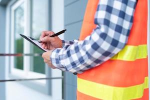 Inspector or engineer is checking and inspecting the building or house by using checklist. Engineers and architects work on building the house before handing it over to the landlord. photo