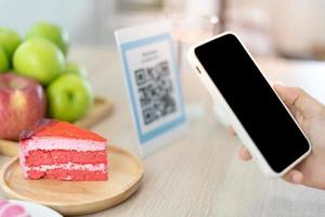 Women use phone to scan qr code to select food menu and collect points. Scan to get discounts or pay for food. The concept of using a phone to transfer money or paying money online without cash. photo