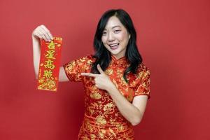 Asian woman holding red fortune blessing Chinese word which means to be blessed by a lucky star isolated on red background for Chinese New Year celebration concept photo