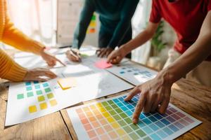 UX developer and ui designer brainstorming about mobile app interface wireframe design with customer breif and color code at office. photo