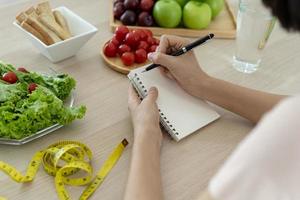 Healthy food. Women plan dieting for slim shape and healthy. Woman eating vegetables, salad and tomatoes photo