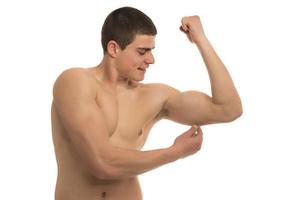 A fit young man pinching body fat on his body photo