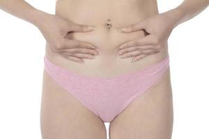 young woman pinching her fat on her body on a white background photo