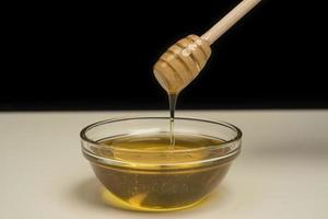 dripping honey on wooden dipper white background with room for copy space photo