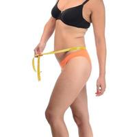 Close up of hand measuring her thin waist with a tape measure. Healthcare and woman diet lifestyle concept. photo