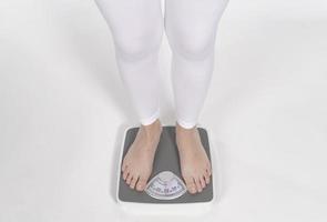 Female bare feet with weight scale photo