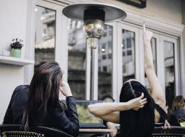 dos novias felices mirando el escaparate mientras están de pie con bolsas de compras cerca del centro comercial foto