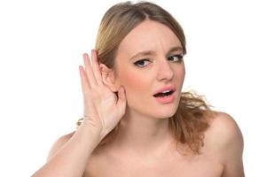 Closeup of Woman holds her hand near ear and listens carefully photo