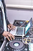 DJ plays live set and mixing music on laptop. Disc Jokey Hands on a laptop at club. photo