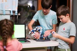 niños aprendiendo a reparar obteniendo un brazo de robot de control de lección, brazo de máquina robótica en taller doméstico, educación científica futura de tecnología. foto