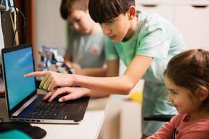 niños aprendiendo a reparar obteniendo un brazo de robot de control de lección, brazo de máquina robótica en taller doméstico, educación científica futura de tecnología. foto