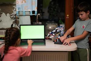 Children learning repairing getting lesson control robot arm, robotic machine arm in home workshop, technology future science education. photo