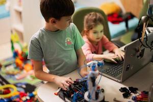 niños aprendiendo a reparar obteniendo un brazo de robot de control de lección, brazo de máquina robótica en taller doméstico, educación científica futura de tecnología. foto