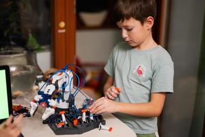 Children learning repairing getting lesson control robot arm, robotic machine arm in home workshop, technology future science education. photo