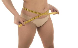 mujer gorda midiendo su estómago con sobrepeso, obesidad. aislado sobre fondo blanco. foto